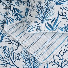 blue and white bedding with corals on it in an ocean theme pattern, close up