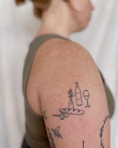 a woman with a tattoo on her arm holding a wine glass in front of her shoulder