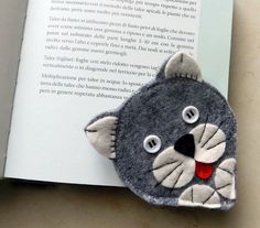 an open book with a felt animal on it