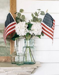 two vases with flowers and american flags in them