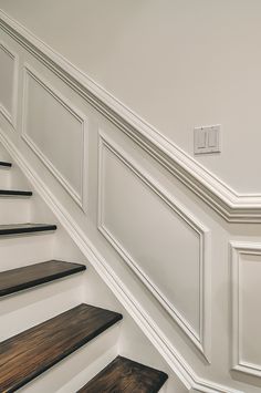 the stairs are lined with wood and white paint