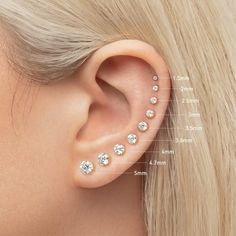 a woman's ear is shown with three different piercings