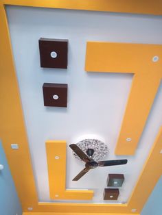 the ceiling is painted yellow and white with square shapes on it, as well as a clock