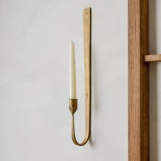 a candle is hanging on the wall next to a door handle and a wooden frame