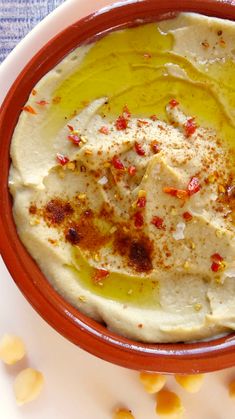 a bowl filled with hummus sitting on top of a table