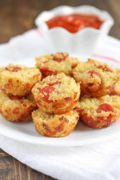 small muffins on a white plate with ketchup in the bowl behind them