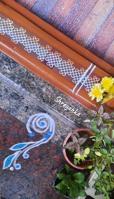 a potted plant sitting on top of a table next to a wooden bench with writing on it