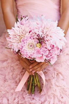 a woman holding a bouquet of pink flowers