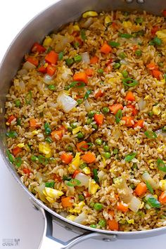 a pan filled with rice and vegetables on top of a stove