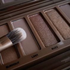 an open makeup palette with a brush in it