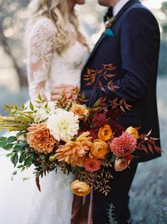 a bride and groom standing next to each other in front of an orange color palette