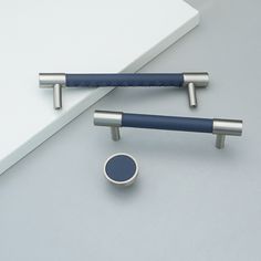 two blue and silver objects sitting on top of a white table next to each other