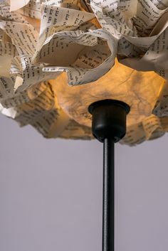 a lamp that has been made out of old sheet music paper and is turned into a flower