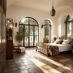 a large bedroom with arched windows and stone flooring, along with a bed in the center