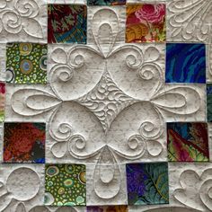 a quilted wall hanging with many different designs on it