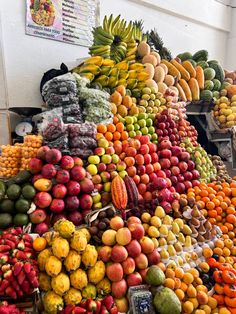 many different types of fruits and vegetables stacked on top of each other in a market