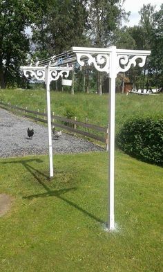 a white gazebo sitting in the middle of a lush green field next to a wooden fence