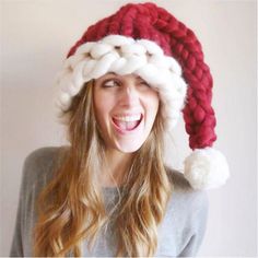 a woman wearing a red and white knitted santa hat