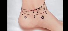 a woman's foot with black beads and hearts on the ankle tattoo designs for women