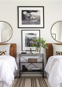 two beds in a room with pictures on the wall