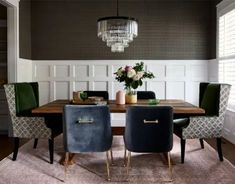 a dining room table with chairs and a chandelier hanging from the ceiling above it