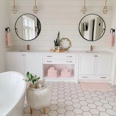 a bathroom with two round mirrors above the bathtub