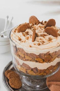 there is a dessert in the glass dish on the table with two cookies next to it