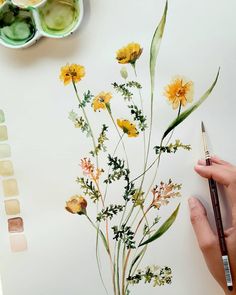 someone is painting flowers with watercolors on paper