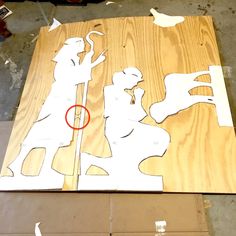 the silhouettes of two people are cut out from plywood and glued to wood