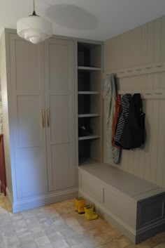 an empty room with white cabinets and yellow shoes