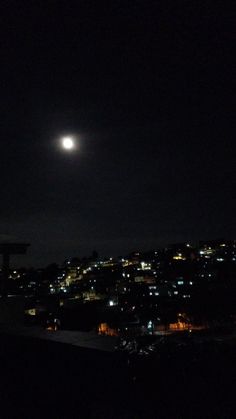 the moon shines brightly in the night sky over a cityscape with buildings