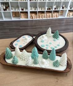 two trays filled with frosted christmas trees and snowmen on top of each other