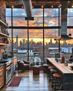 an open kitchen and living room with large windows overlooking the city at sunset or dawn