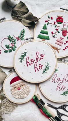 four embroidery hoops with santa's hat, holly wreath and other christmas decorations