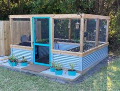 a small backyard garden shed with plants in the center and an enclosed area behind it