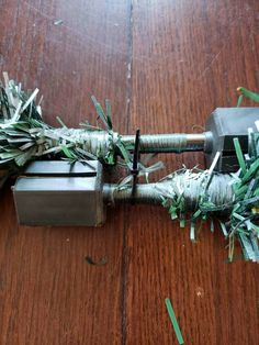 a piece of metal and some branches on a wooden table