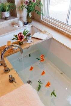 a bathtub filled with lots of water and orange slices floating on top of it