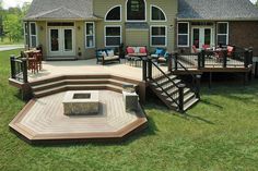 a house with deck, fire pit and seating area in the front yard is shown