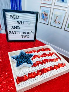 a red, white and blue flag cake is on display in front of a sign