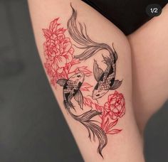 a woman's thigh with a koi fish and peony flowers on it