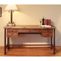 a wooden desk with a lamp on top of it next to a book and some books