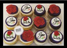 twelve cupcakes decorated with red and purple frosting, rose on the top