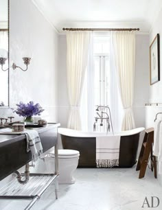 a bath room with a tub a toilet and a sink