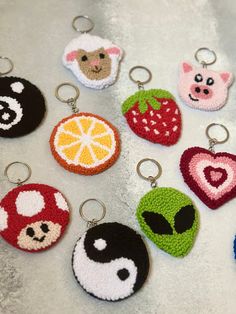 six crocheted keychains with fruit and animals on them, all in different colors