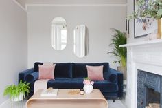 a living room filled with furniture and a fire place in front of a mirror on the wall