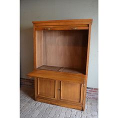 a wooden cabinet sitting on top of a brick floor