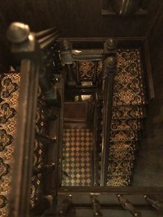 an overhead view of a staircase with decorative tile flooring and metal handrails