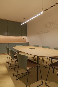 an empty conference room with chairs and a large table in front of a wall that reads ion