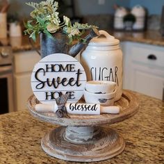 a kitchen counter top with a vase, mugs and other items on the table