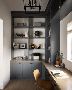 an office with gray cabinets and wooden flooring is pictured in this image, there are two chairs at the desk